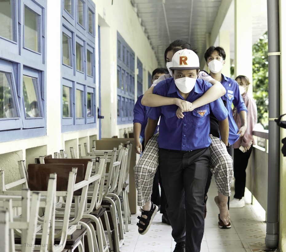 Tình nguyện viên cõng thí sinh bị gãy chân, ngồi xe lăn vào phòng thi