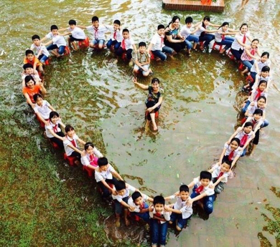 HS lớp 5 xếp hình trái tim chụp ảnh kỷ yếu giữa sân trường ngập nước