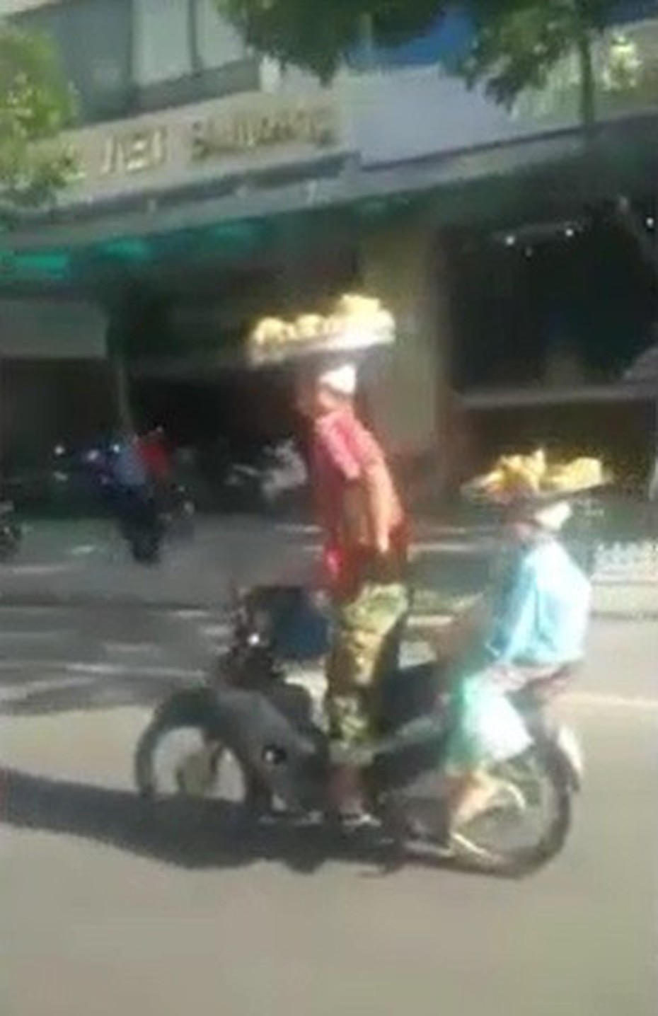 Đi xe máy đội bánh trên đầu, hai bố con khiến dân mạng choáng váng