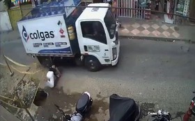 Người phụ nữ bế con bất ngờ vấp ngã, suýt bị bánh xe tải cán trúng