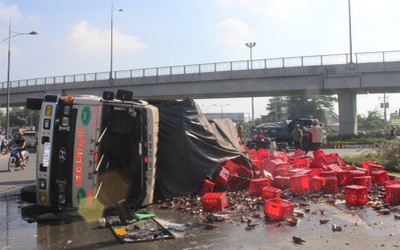 Xe chở bia lật, 2 người đi xe máy bị hàng trăm két bia vùi lấp