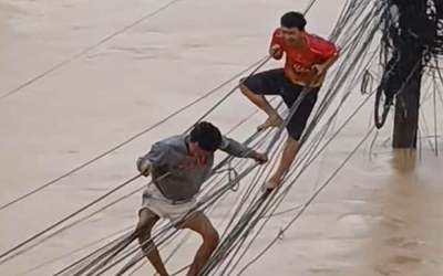 Người dân liều mình đu bám trên đường dây điện để thoát khỏi lũ lụt