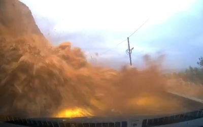 Đất đá từ sườn đồi đổ xuống đường, vùi lấp ô tô con