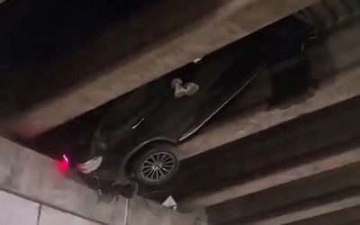Mercedes mắc kẹt giữa dầm cầu vượt cao 6 mét, chân tài xế thò ra ngoài