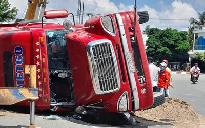 Container chở hàng lật ngang giữa đường, người đi xe máy thoát chết