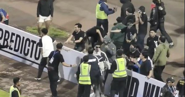 Cổ động viên tức giận tràn vào sân tấn công cầu thủ đối phương