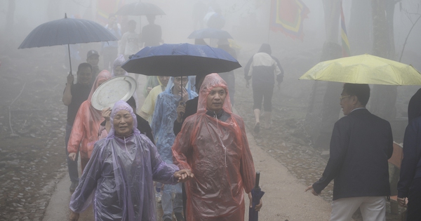 Trong màn mưa, dòng người vẫn đổ về 